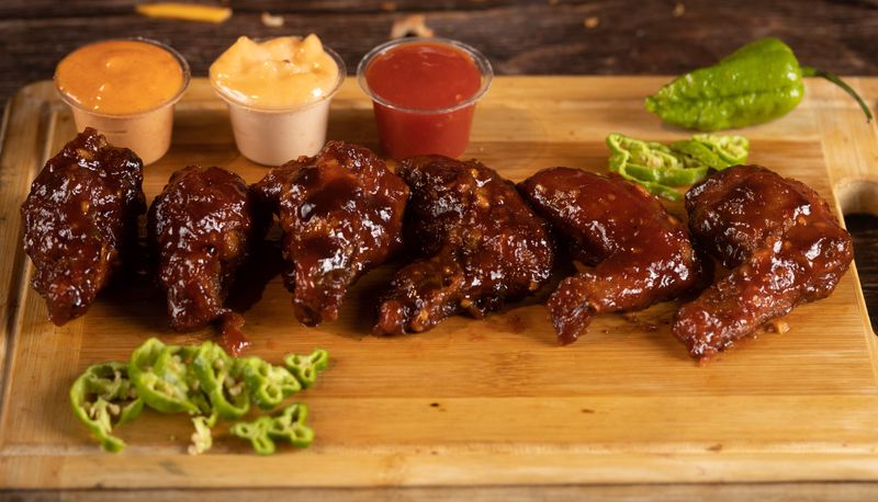 Loaded wing platter with multiple sauces and sides at Wing Snob