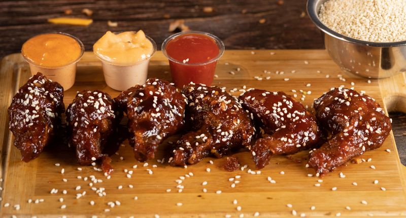 Wing Snob signature saucy wings piled high on a platter